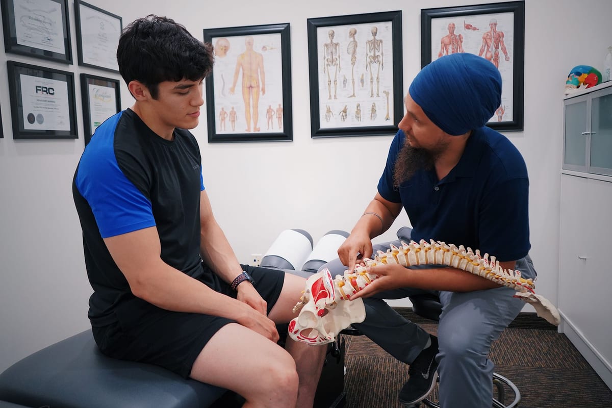 A practitioner explaining the spine to a patient with a spine model