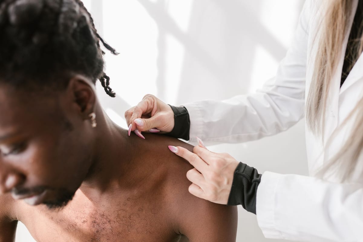 A practitioner examining a patient's shoulder