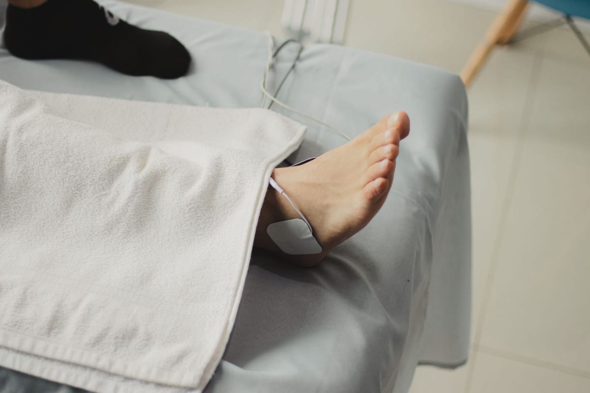 A patient's foot being treated on a clinic bed